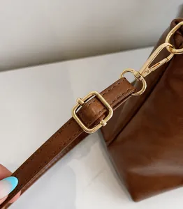 Gros plan sur la bandoulière réglable avec boucle dorée et finitions de couture nettes