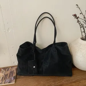 Large black suede tote bag with minimalist design and matching small pouch for commute