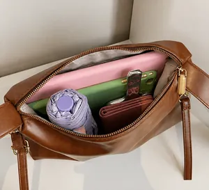 Vue de dessus du sac bandoulière en daim marron avec doublure rayée et grand espace