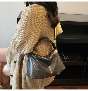 Détail du sac hobo en daim noir avec une texture douce et une large bandoulière