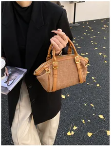 Detailed shot of retro woven texture and brown leather accents on a Boston handbag