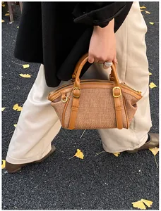 Detail of vintage Boston bag with brown textured fabric and caramel leather handles
