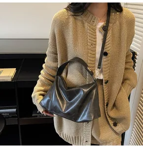 Détail du sac cabas noir en daim avec boucles en métal doré et bandoulière large