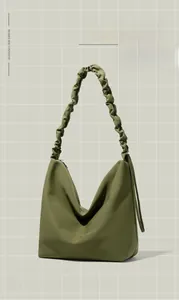 Detail of adjustable pleated shoulder strap on olive green nylon tote bag