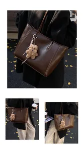 Détail d'un sac cabas en cuir marron foncé avec breloque ours en peluche et bandoulière