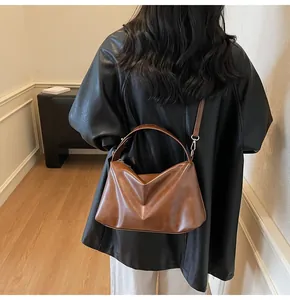 Vue détaillée du sac en daim marron caramel avec pli en V et longue bandoulière
