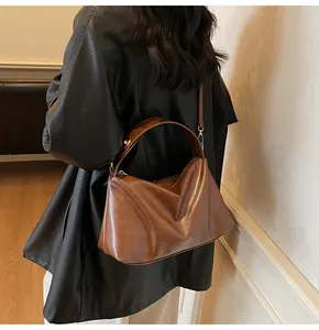 Vue détaillée du sac bandoulière en daim marron avec texture plissée sur modèle