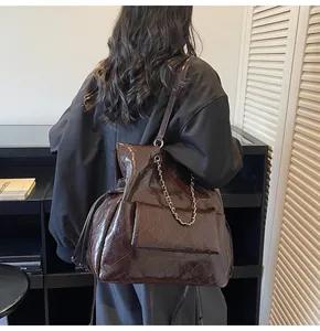 Dettaglio borsa tote trapuntata marrone scuro con catena dorata e coulisse interna