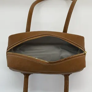 Brown leather shoulder bag with white contrast stitching and a spacious interior