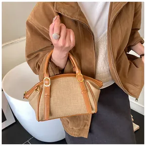 Detail shot of the woven khaki fabric and brown leather trim on the vintage crossbody bag