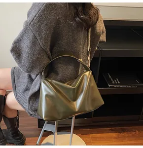 Gros plan d'un sac cabas mat vert olive avec bandoulière réglable dans un décor lifestyle