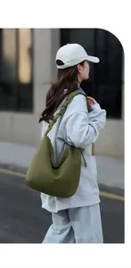 Detail of olive green tote bag featuring ruffle shoulder strap and waterproof nylon fabric