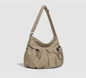 Vue latérale du sac fourre-tout en nylon kaki avec poches à cordon et large bandoulière