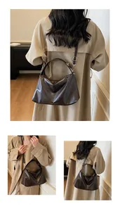 Détail d'un sac à main en similicuir marron café avec finitions métalliques dorées chic