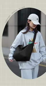 Detail view of lightweight durable black crescent tote bag with wide shoulder strap