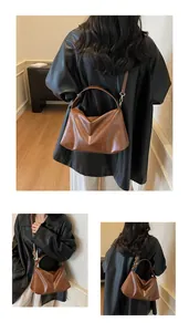 Détails du sac à bandoulière en daim givré marron avec texture plissée et sangle
