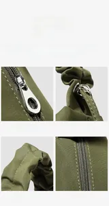 Detail view of olive green pleated nylon bag with adjustable strap and silver metal hardware