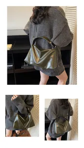 Détails du sac à bandoulière en daim vert foncé montrant la poignée large et la bandoulière