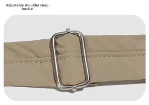 Détail de la bandoulière réglable en nylon kaki avec une boucle en métal argenté