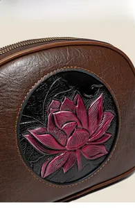 Detail of embossed lotus pattern on brown leather bag with high-quality stitching