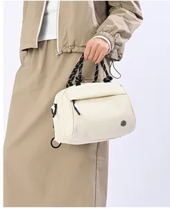 Close-up of cream nylon handbag featuring a unique black and white braided rope handle