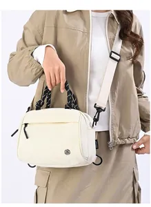 Detail of cream white nylon crossbody bag featuring woven handles and wide strap