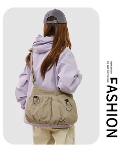 Sac bandoulière en nylon kaki avec poches à cordon et sangle réglable sur un modèle