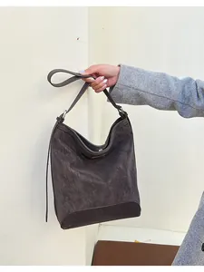 Detail of vintage charcoal grey large bucket bag with textured faux leather and long strap