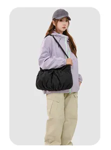 Détail du sac fourre-tout plissé en nylon noir avec cordon sur un mannequin femme