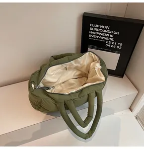 Detailed view of olive green quilted tote bag showing smooth zipper and inner pocket