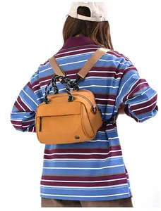 Detail of yellow nylon crossbody bag with woven handles and adjustable shoulder strap