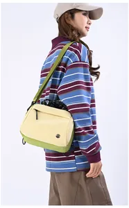 Detail view of contrast color crossbody bag with rope handle and wide shoulder strap
