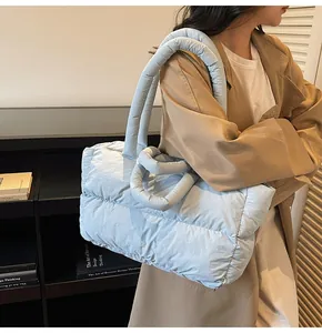 Detail of light blue quilted tote bag showing plush padded handle and cloud texture