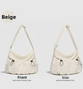 Vue détaillée d'un sac cabas croissant en nylon beige avec cordons avant et latéraux