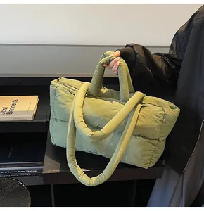 Detail of green quilted puffer tote bag with thick padded handle and large capacity