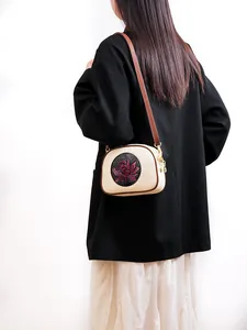 Detail view of the red 3D lotus relief on white Chinese style crossbody Boston bag