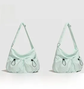 Vues de face et de profil du sac bandoulière en nylon vert clair avec poches plissées