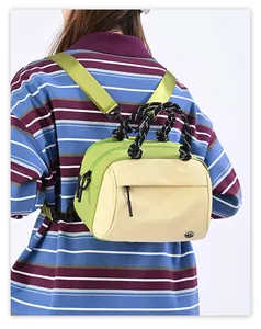 Detail of green and beige crossbody bag with patterned rope handle and adjustable strap