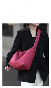 Detailed view of magenta tote bag with ruched shoulder strap on a fashion model
