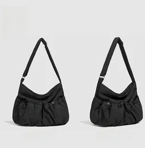 Vue détaillée de face et de côté du sac à bandoulière en nylon noir avec poches à cordon
