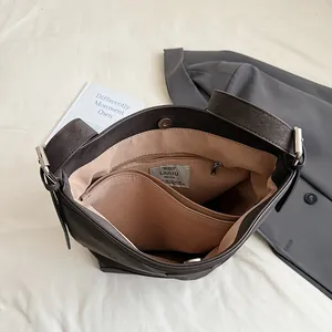 Deep brown bucket bag featuring a spacious interior with khaki lining and a zipper pocket