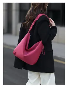 Detail of rose red tote bag featuring unique scrunched shoulder strap and soft nylon texture