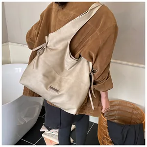 Detail view of khaki oil wax leather tote bag with stylish side bow knot on shoulder strap