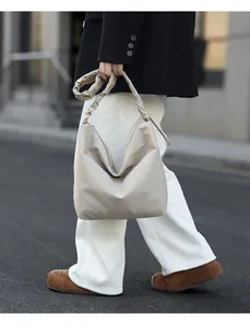 Detail of cream hobo bag featuring a stylish pleated handle for an urban commute look