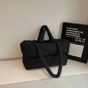 Quilted puffer tote bag in black nylon with padded shoulder handles for winter style