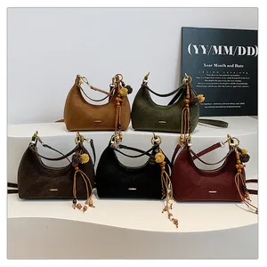 Detailed close-up of retro suede crescent underarm bags in five vintage colors with tassel