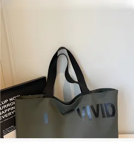 Detail of army green canvas tote bag with black VIGOURVIVID logo and nylon handles
