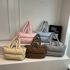Quilted down cotton tote bags in five pastel colors displayed on a minimalist white stand