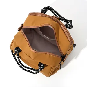 Minimalist yellow nylon shoulder bag with woven handles and spacious inner compartment