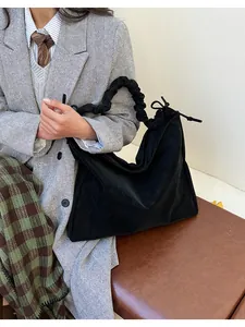 Detail of black tote bag with unique ruched cloud handle and drawstring on a model